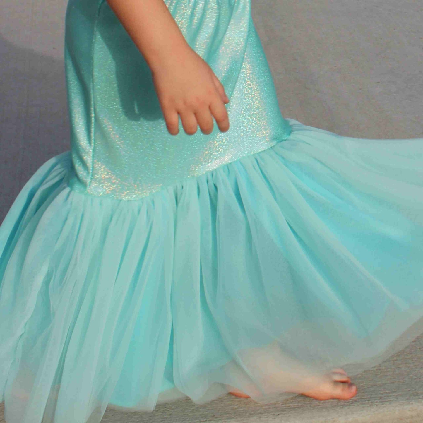 a little girl dressed in a blue dress