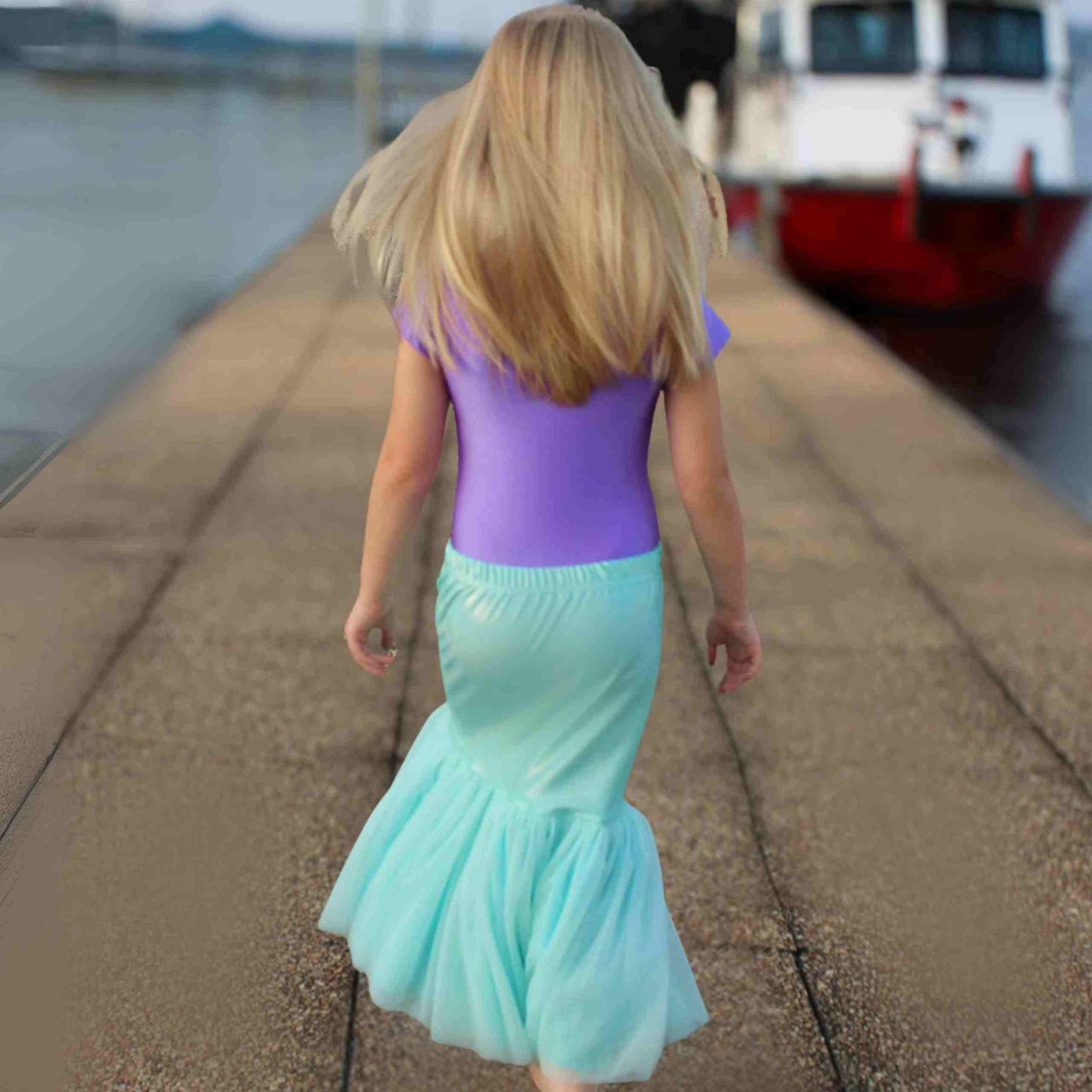 a little girl that is walking down a sidewalk