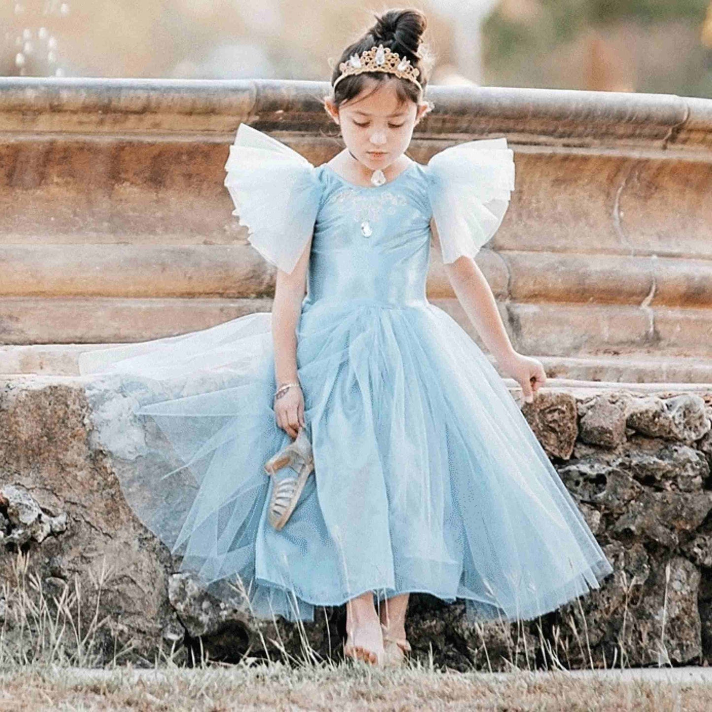 a little girl dressed in a blue dress