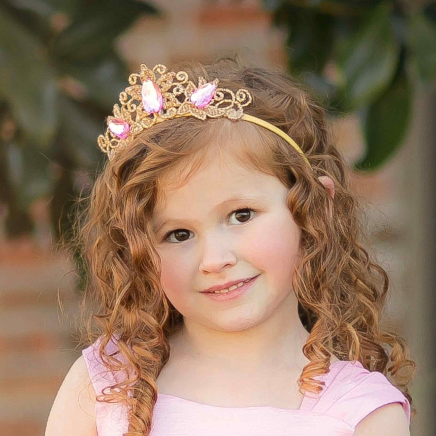 a little girl wearing a tiara and smiling