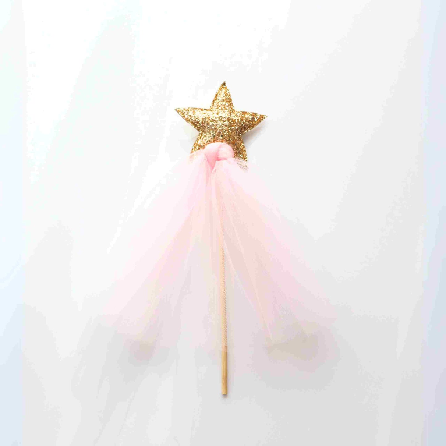 a pink and gold star wand on a white background