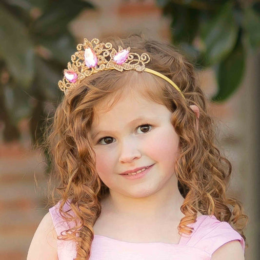 a little girl wearing a tiara and smiling