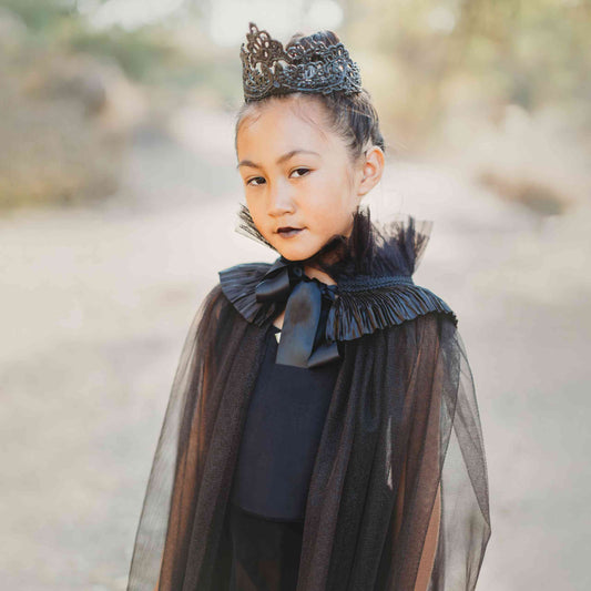 a little girl wearing a black cape and a tiara