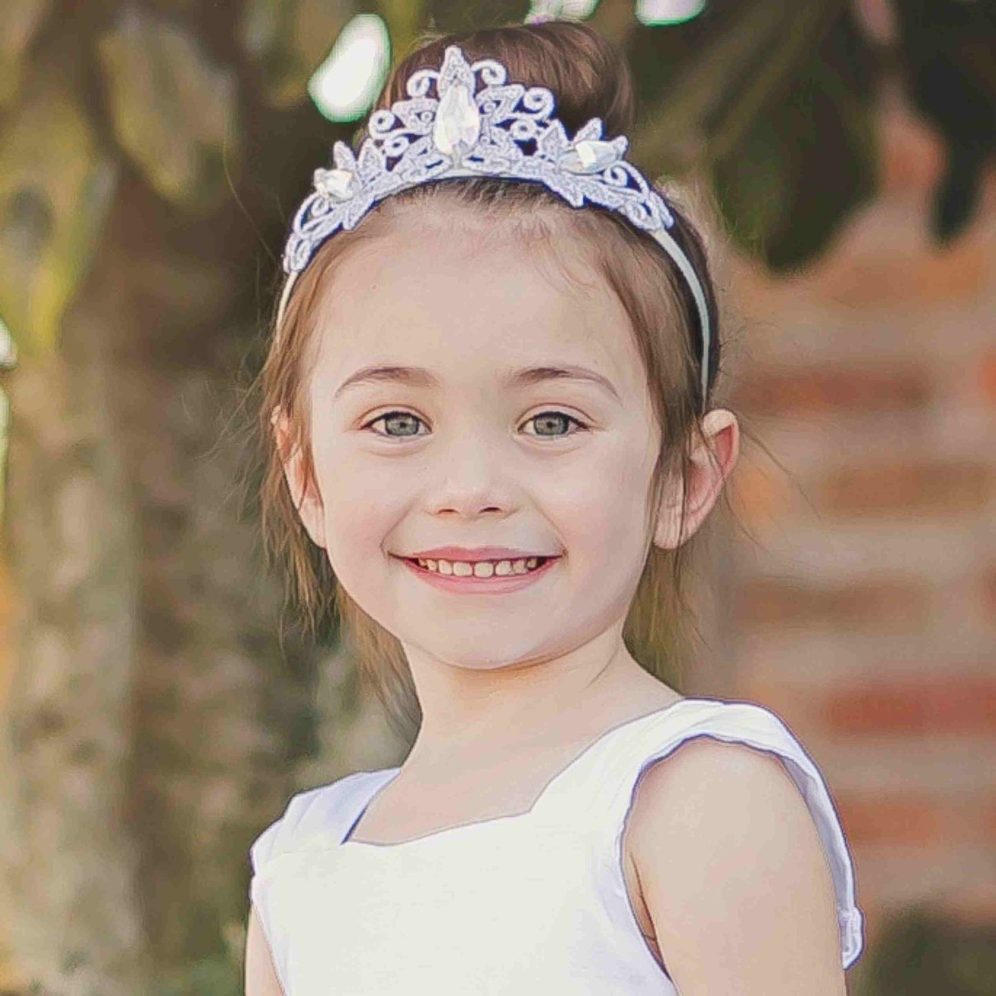 a little girl wearing a tiara smiling for the camera