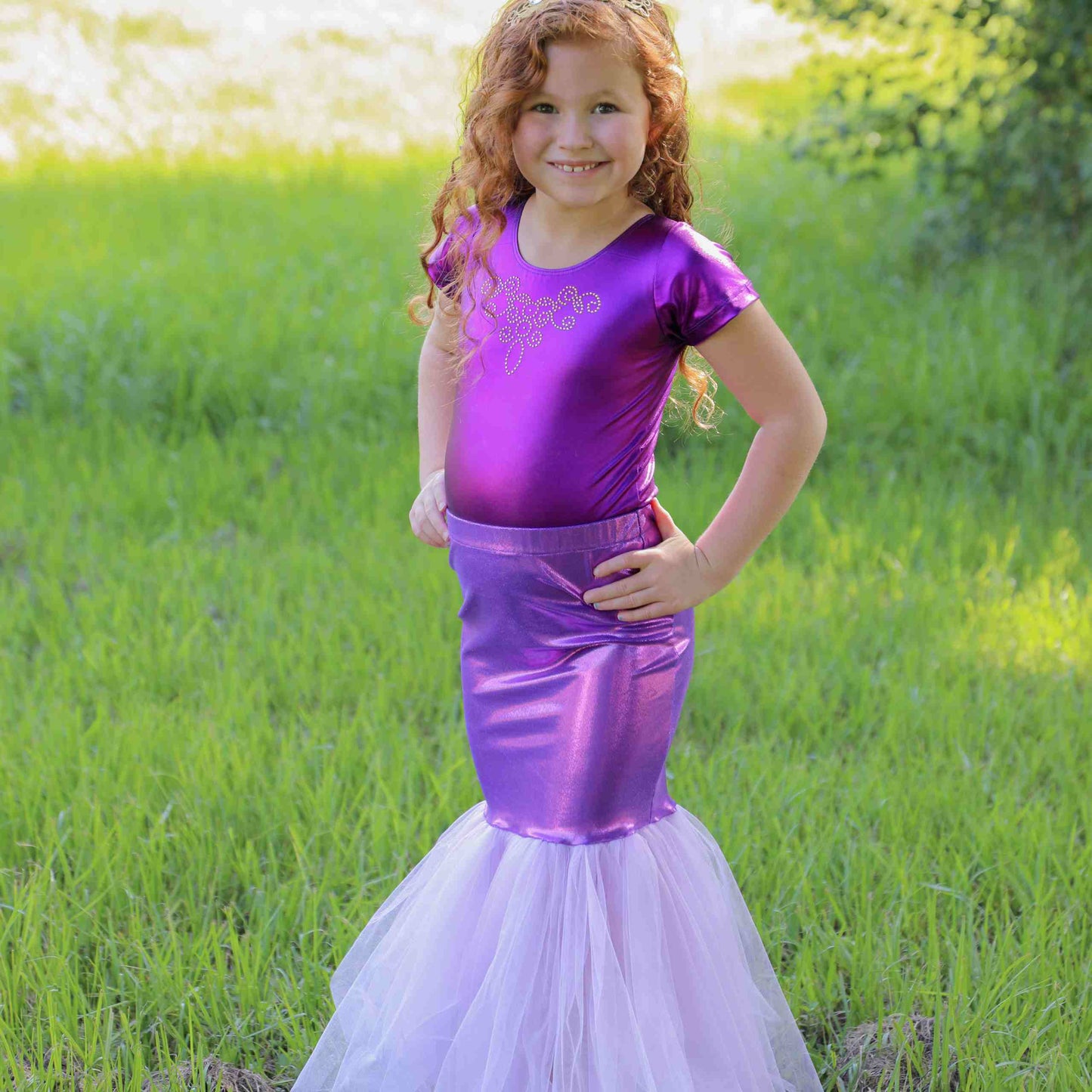 a little girl in a purple mermaid costume