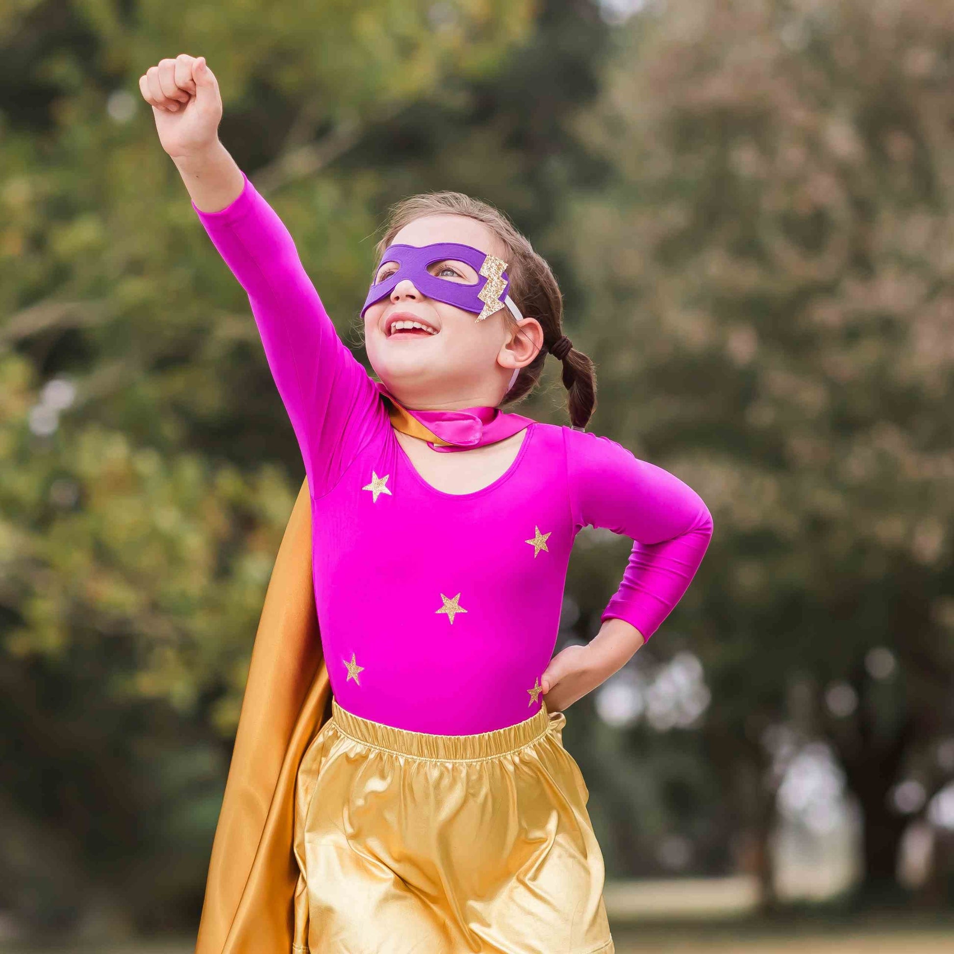 a little girl wearing a purple mask and gold pants