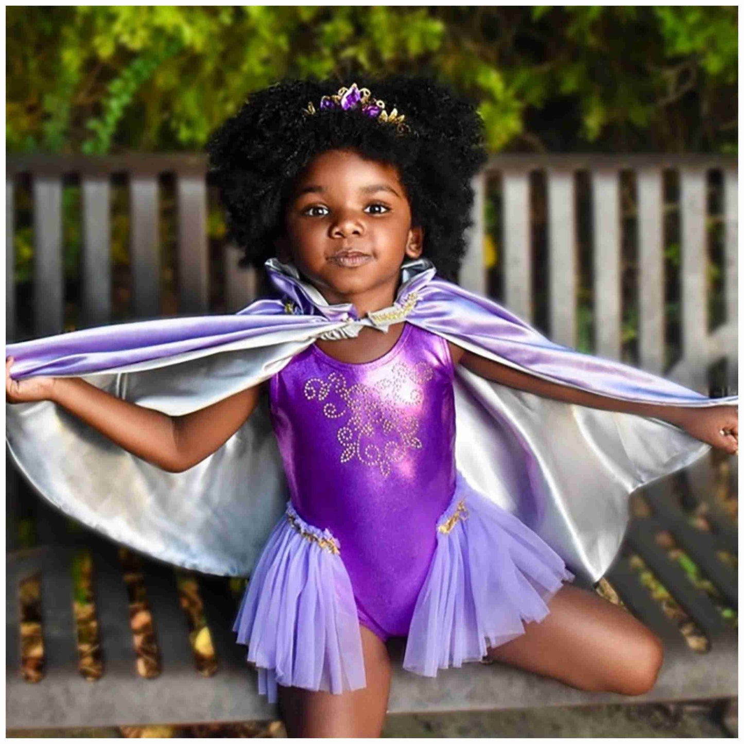 a little girl dressed in a purple leotard