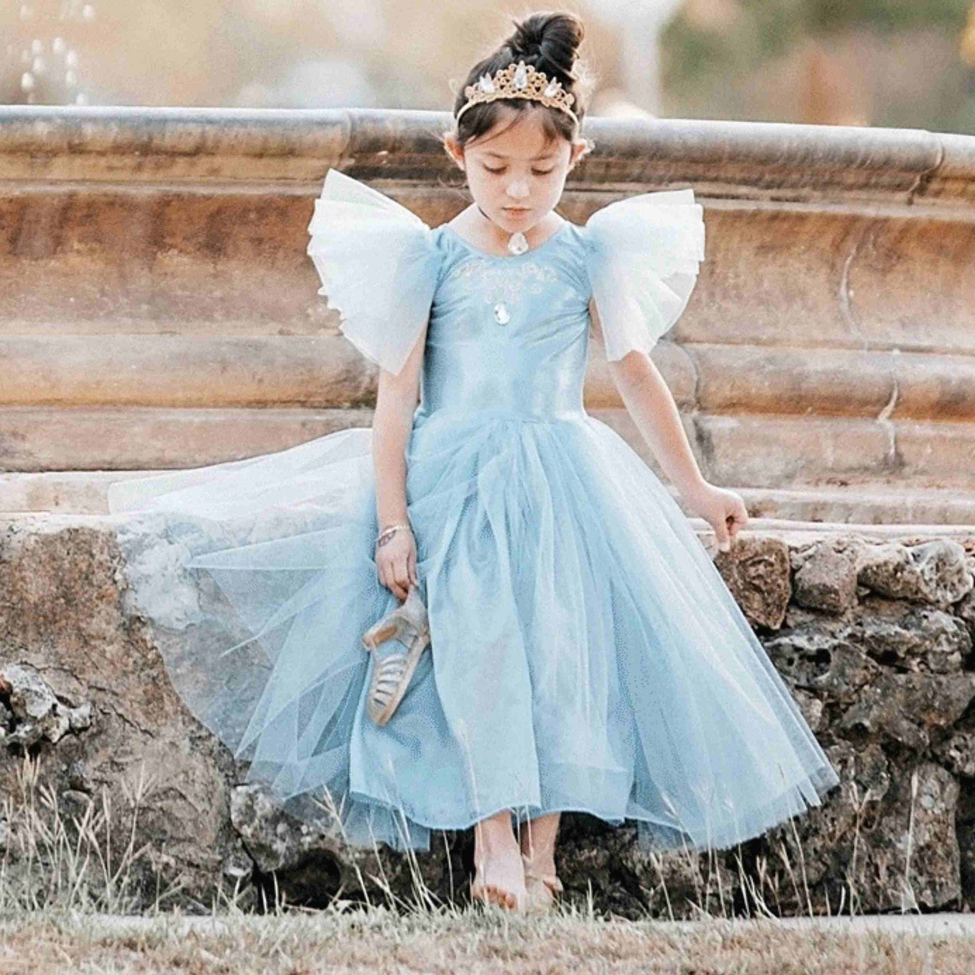 a little girl dressed in a blue dress
